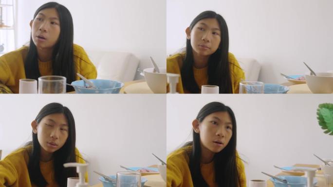 亚洲女孩穿着黄色毛衣，在家享受美食，检疫生活理念。