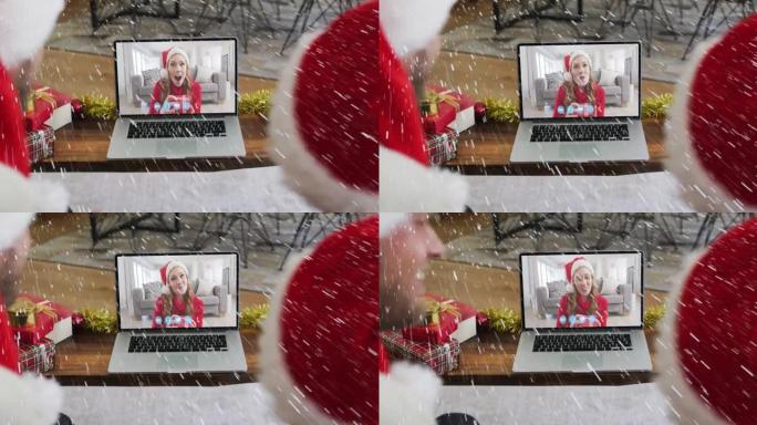 在与家人的笔记本电脑视频通话中，雪花落在圣诞老人帽子上的微笑夫妇身上的动画