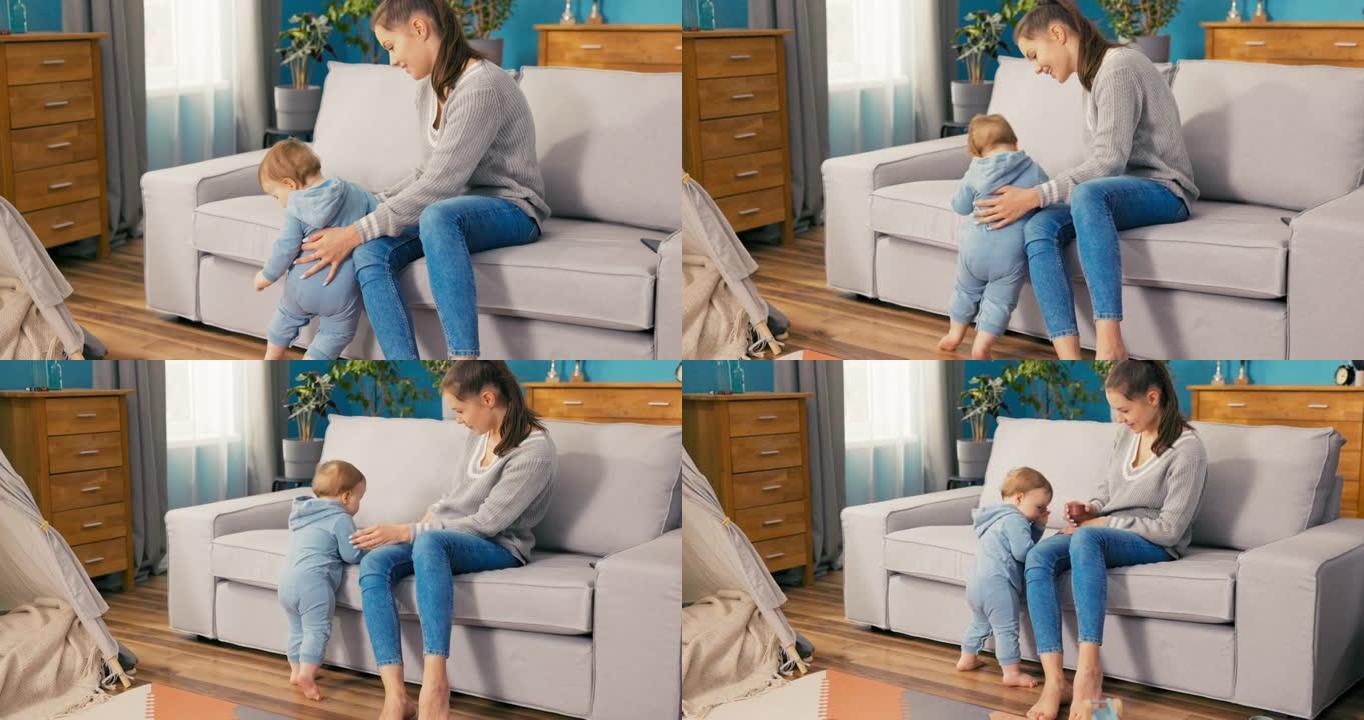 有爱心的母亲和儿子一起坐在家里，看着他，男孩用两条腿坐在沙发上站在客厅，学会平衡，了解世界，看着玩具