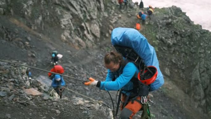 一名攀岩者用绳子爬到落基山脉的山顶。