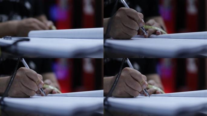 作家在白纸上写字时握着笔的手