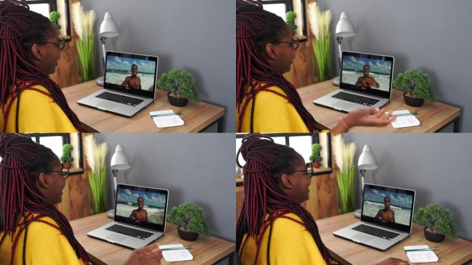 4k视频开朗的年轻的非洲裔美国妇女，戴着眼镜，用笔记本电脑进行视频通话，并与一名非洲裔美国男子交谈