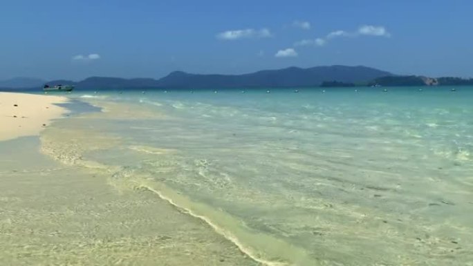 热带岛屿上的海水冲洗沙质海岸的透明水域