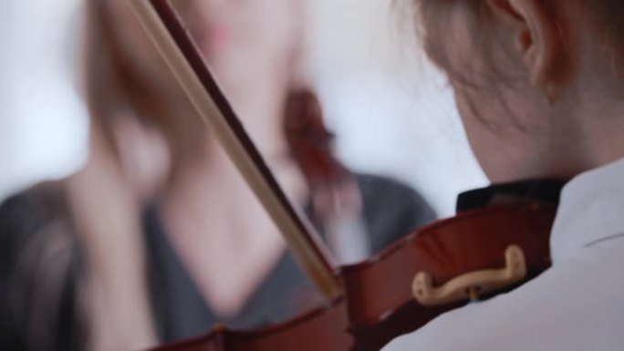 一个女孩和她的女老师一起学习拉小提琴