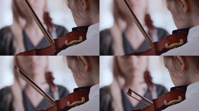 一个女孩和她的女老师一起学习拉小提琴