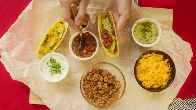 餐桌上的传统墨西哥食物，德克萨斯墨西哥美食。烹饪肉玉米卷或墨西哥卷饼，将番茄酱和香菜放在里面，鳄梨色