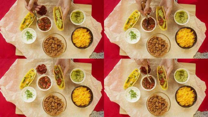 餐桌上的传统墨西哥食物，德克萨斯墨西哥美食。烹饪肉玉米卷或墨西哥卷饼，将番茄酱和香菜放在里面，鳄梨色