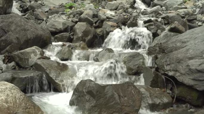 水流溅在山间瀑布的石头上