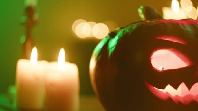 南瓜灯和燃烧的蜡烛特写。木桌上刻有火焰的雕刻南瓜。万圣节符号，吓人的脸，传统的秋季节日装饰品