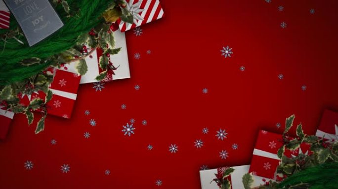 雪花落在红色背景下的圣诞花环装饰和礼物上