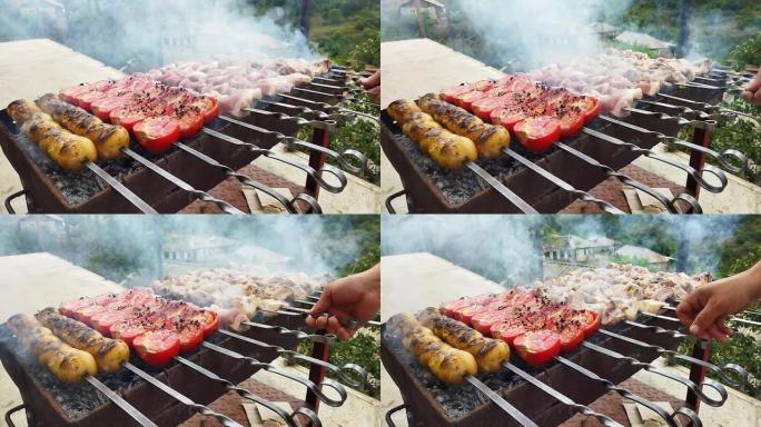 厨师在村子里准备烧烤。猪肉着火了。火上的红色西红柿、黄色短裤和猪肉。厨师的飞行菜