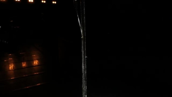 在黑暗舞台上的麦克风在光束中。