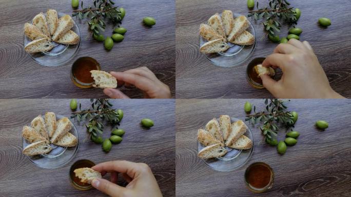 一个女人把面包浸入摩洛哥坚果油中。健康的摩洛哥开胃菜和小吃。