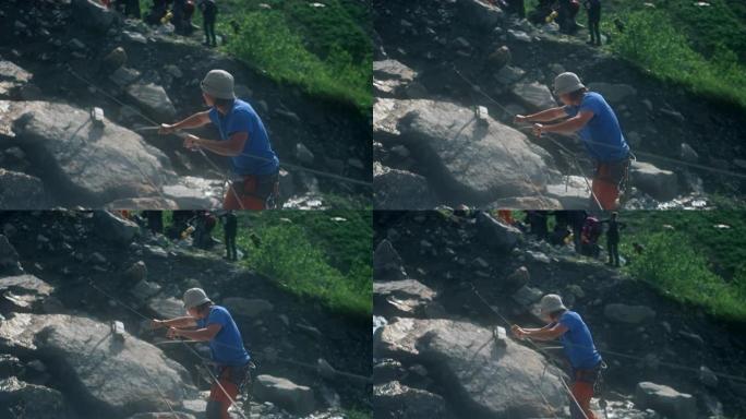 。一名游客使用用登山扣固定的垂直绳索过河。