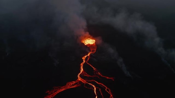 夜间活火山的鸟瞰图。分支熔岩流从火山口流出的沸腾岩浆。法格拉达尔斯福杰尔火山。冰岛，2021