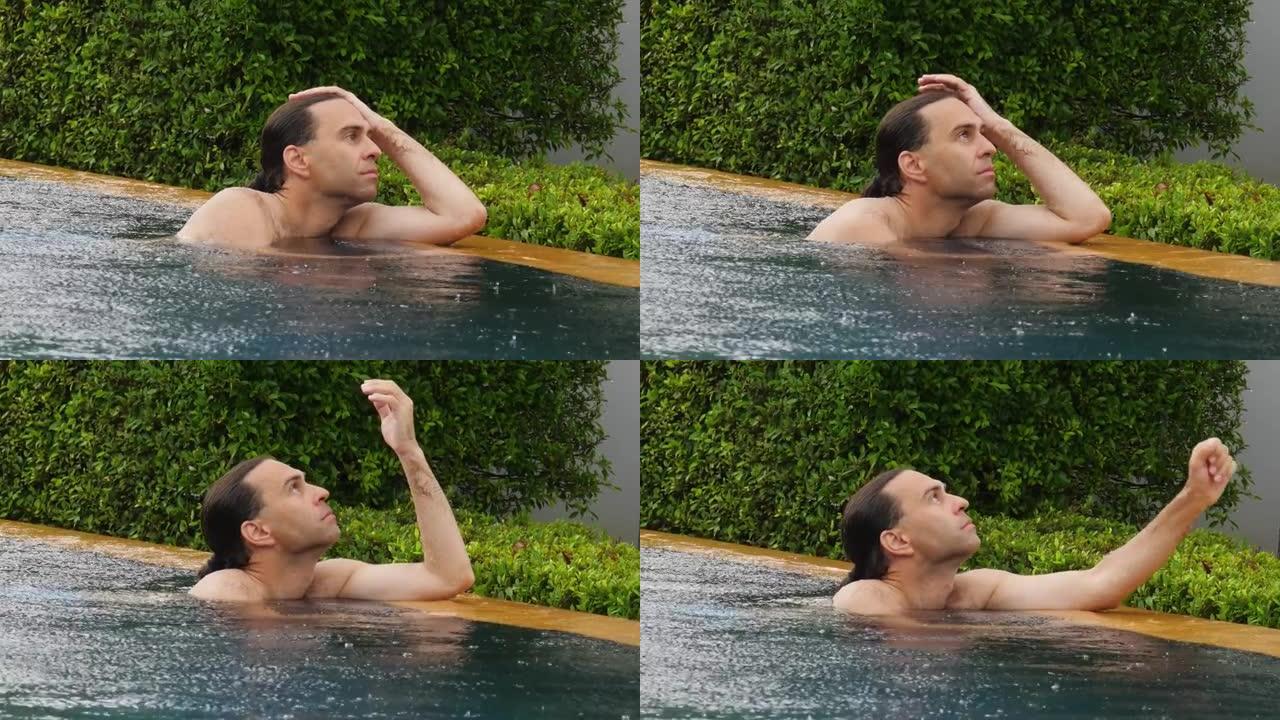 内向的男人在雨中呆在游泳池里，凝视太空，放下手