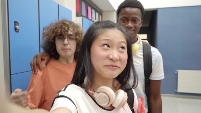 一群正在上高中的学生的视频通话。开朗的多民族同学用手机在线笑。
