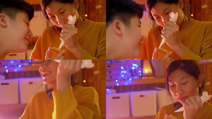 亚洲男孩看着他的妹妹在晚上在家一起装饰糖衣饼干，万圣节的生活方式概念。