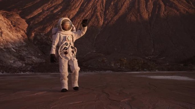 宇航员远离悬崖，举起手，从明亮的阳光下关闭