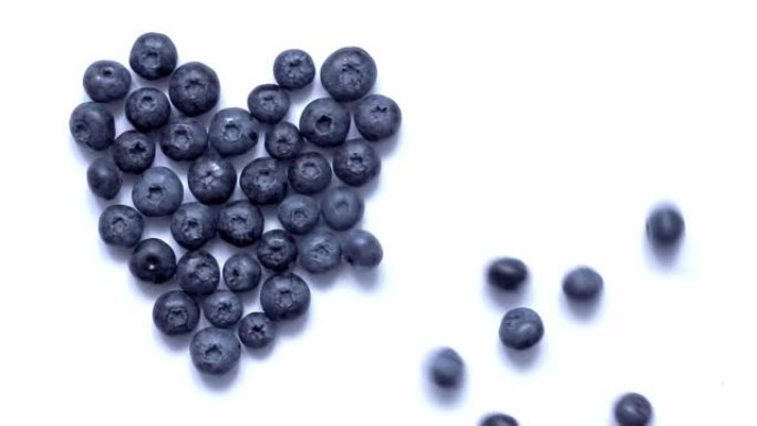 浆果在白色背景上向蓝莓心滚动。