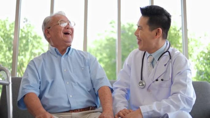 亚洲医生给予同情鼓励退休患者坐在家庭医院的沙发上