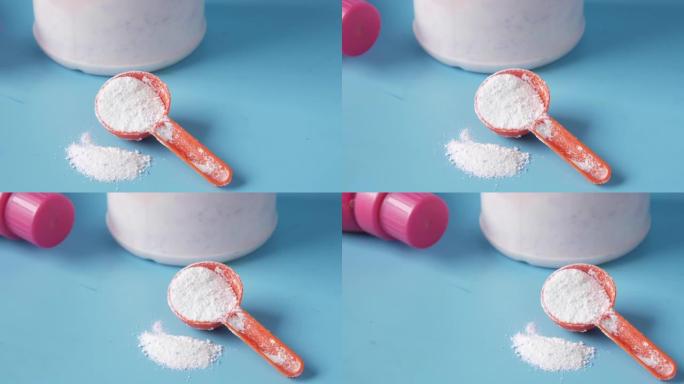 蓝色背景塑料勺子洗衣粉