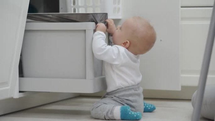 家庭对孩子有许多潜在的危险，婴儿打开柜子在厨房柜台下抓取和玩耍拉出垃圾桶，儿童在家中安全。