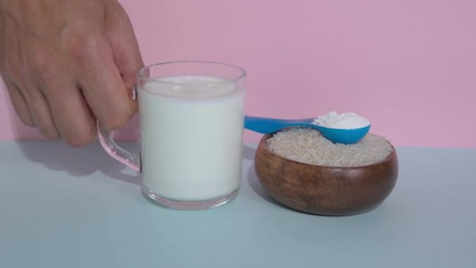 纯素食米浆粉。五彩背景上的一杯牛奶