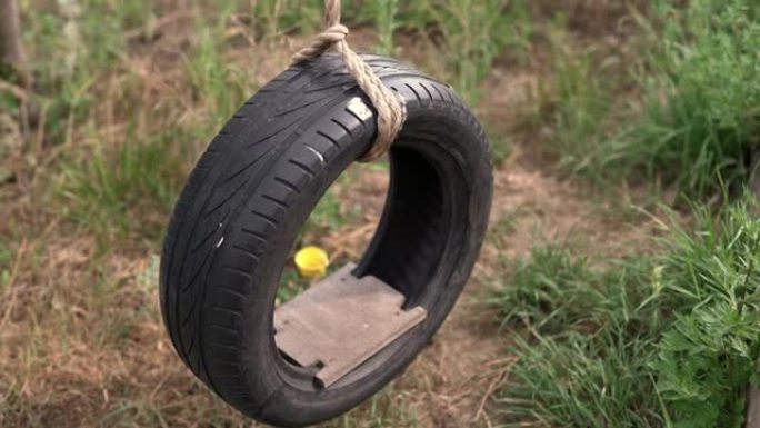 由木圆木制成的结构上的汽车轮胎的秋千