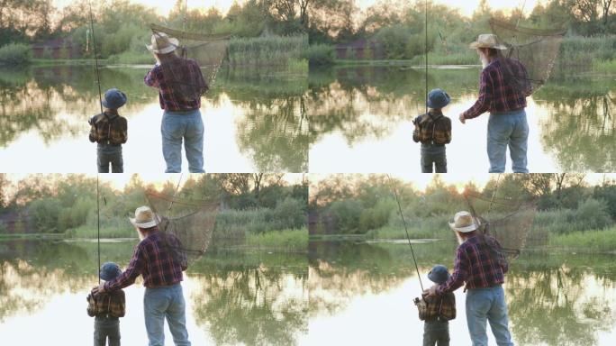 迷人的受人尊敬的大胡子渔民的后景，他和他感兴趣的小孙子一起站在池塘的岸边，在钓鱼前说话