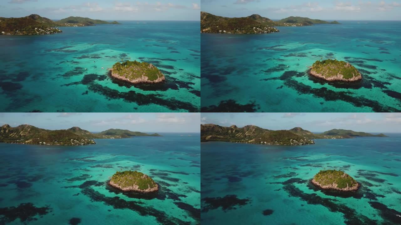 环绕加勒比海礁的空中无人机视图，背景上出现了一个主要岛屿