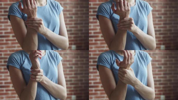 女人按摩手臂酸痛的手，前视图。女人在她的手上拉韧带并摩擦它。女性隧道综合征