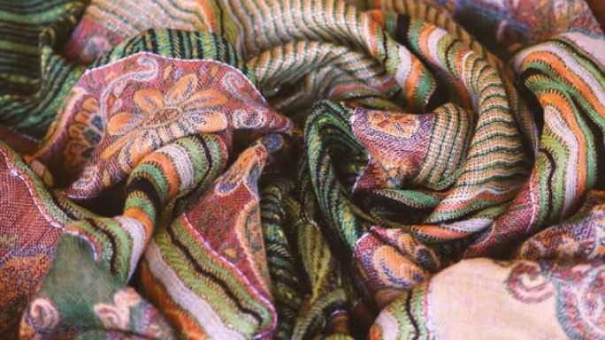 优雅的彩色围巾，面料，披肩，橙色，金色，绿色，混色。抽象织物背景图案。