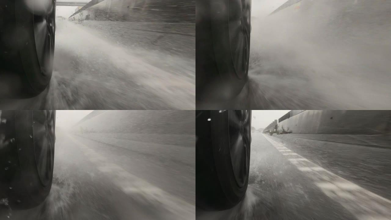 雨天在高速公路上行驶。汽车轮胎和飞溅的水。慢动作。