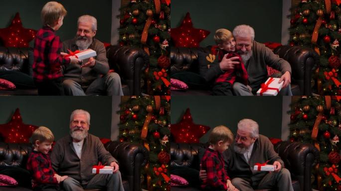 可爱的小男孩给他的祖父一个很棒的圣诞夜礼物。一位年迈的祖父在一棵发光的圣诞树附近的装饰房间里拥抱他的