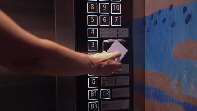 使用感应卡解锁电梯的女人。