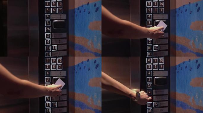 使用感应卡解锁电梯的女人。