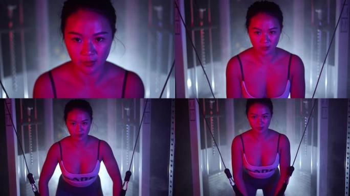 亚洲女性做电缆飞胸运动的特写镜头。