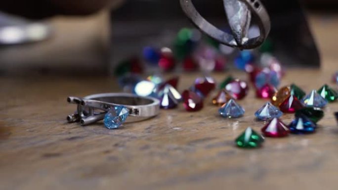 手工珠宝制作过程。珠宝商制作和清洁珠宝。用火硬化金。研磨和抛光一个金戒指。