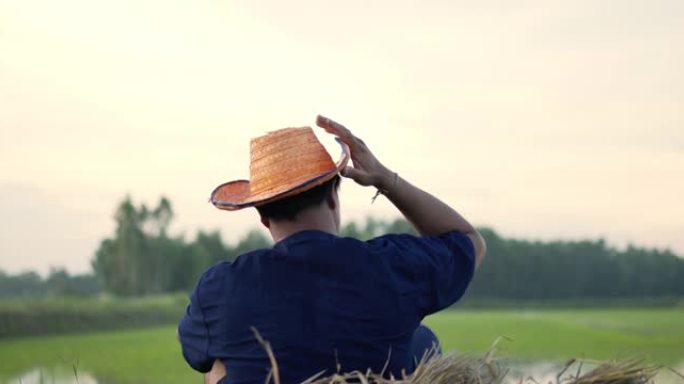 年轻的农民在田间种植水稻后擦汗