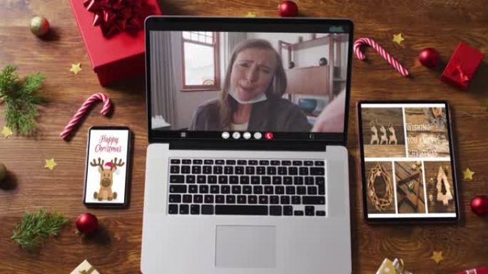 快乐的高加索高级女性视频通话，智能手机，平板电脑和圣诞节装饰品