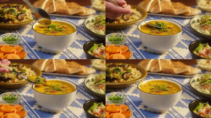 在桌子上吃豆汤特写。阿拉伯美食。皮塔饼和碾碎干小麦，蒸粗麦粉背景。传统中东文化。美味的米饭和肉。自制