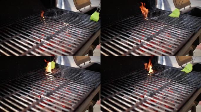 绿色烹饪刷将油涂在热烟烤架上，产生强烈的火焰，关闭。