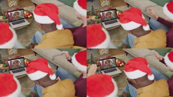 拥有圣诞老人帽子的多元化家庭使用笔记本电脑进行圣诞节视频通话，屏幕上有男孩