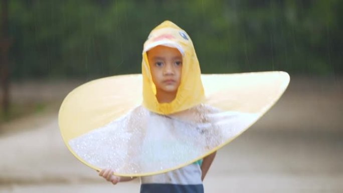 亚洲小男孩在雨中玩水。