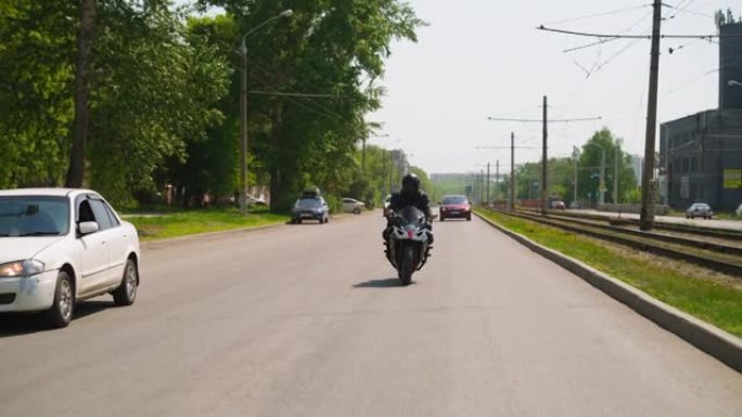 骑自行车的人沿着经过电车路线的道路骑快速摩托车