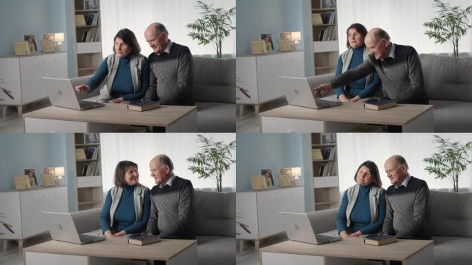 恩爱的老年夫妇一起玩得开心，坐在客厅的沙发上浏览笔记本电脑上的网上购物