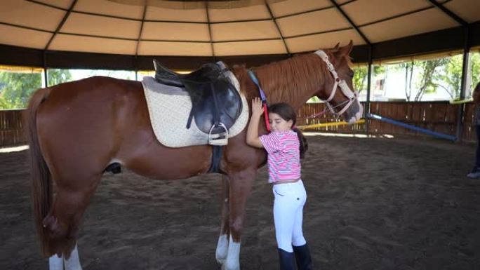 小女孩给她的马一个友好的拥抱。