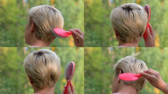 一个金发女孩，短发，用红色梳子梳头发，头部按摩器，特写视频肖像