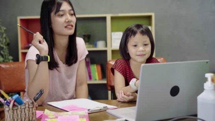 亚洲母亲在家上学期间帮助女儿。